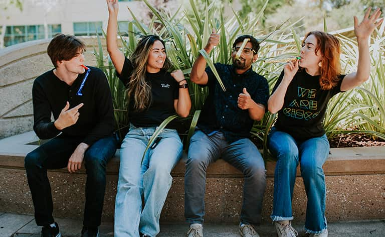 Four people making celebratory gestures.