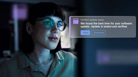 one woman’s face lit up by monitor with a verified update notification over image