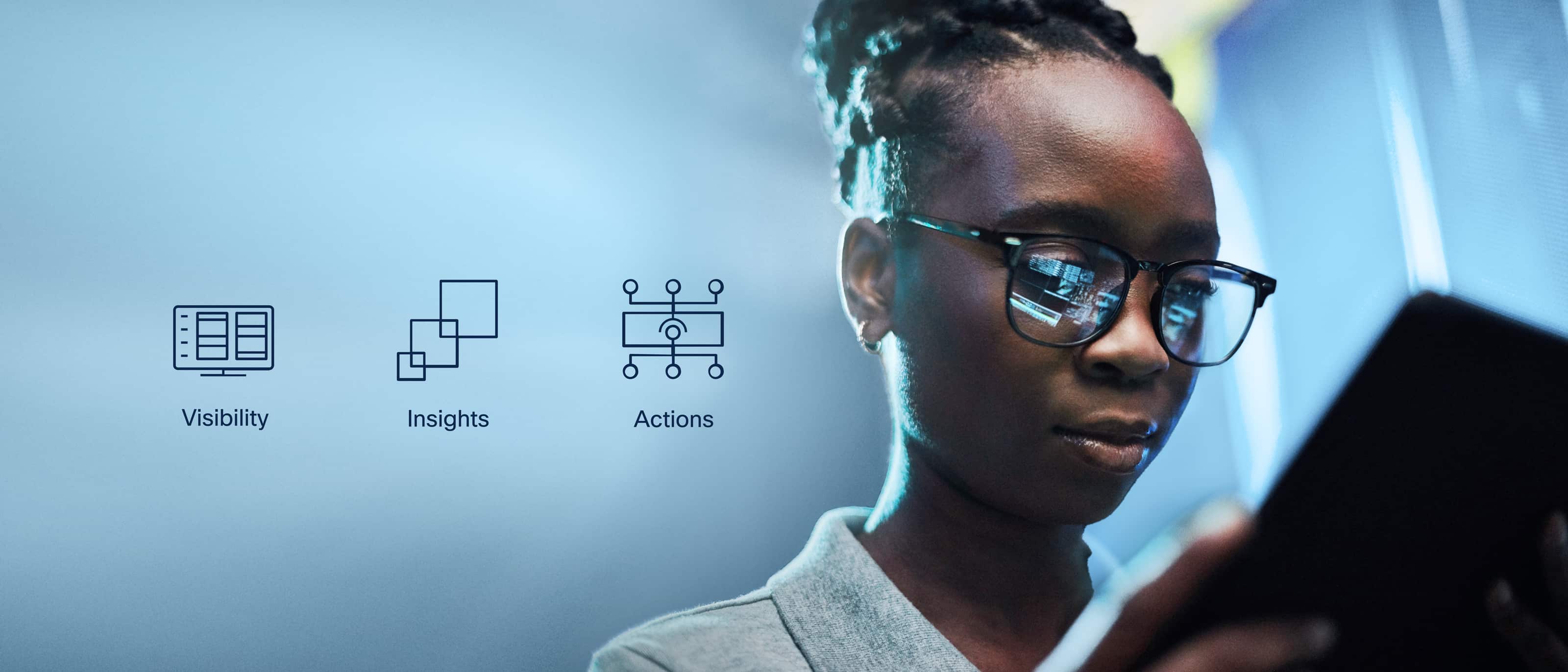 IT professional monitoring networks on a laptop in a data center. Icons hover to the side representing Visibility, Insights and Actions