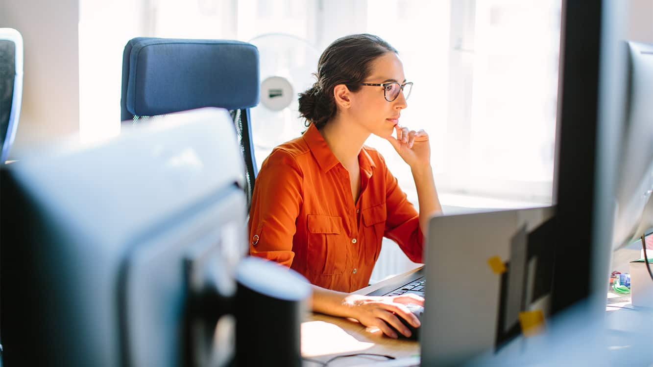 Shot of business woman sitting at her desk and working on desktop computer